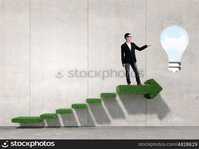 Guy presenting bright idea. Young student guy in jacket showing light bulb in palm