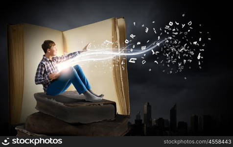 Guy reading book. Teenager boy wearing jeans and shirt and reading book