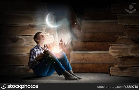 Guy reading book. Teenager boy wearing jeans and shirt and reading book