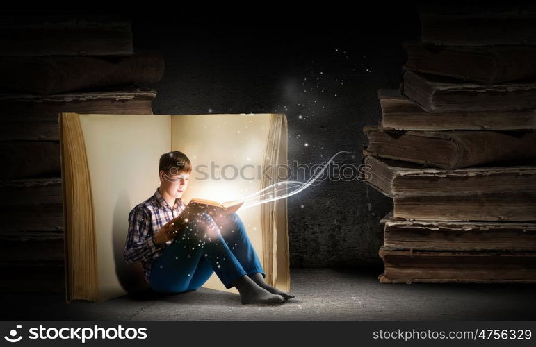 Guy reading book. Teenager boy wearing jeans and shirt and reading book