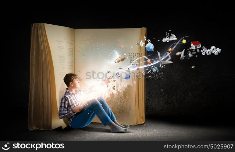 Guy reading book. Teenager boy wearing jeans and shirt and reading book