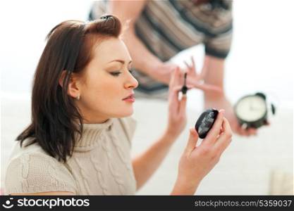 Guy trying to hurry up girlfriend applying make-up