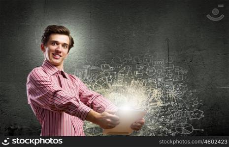 Guy using tablet pc. Young man looking shocked in tablet pc