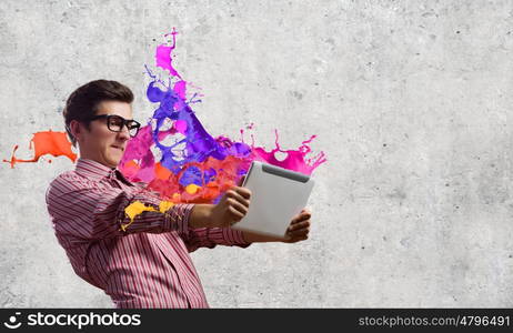 Guy using tablet pc. Young man looking shocked in tablet pc