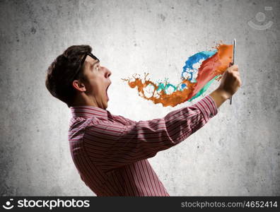 Guy using tablet pc. Young shocked man with tablet pc in hands