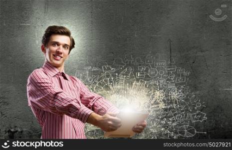 Guy using tablet pc. Young smiling man with tablet pc in hands