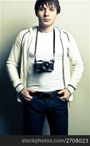 Guy with a photocamera on light background. Contrast image.