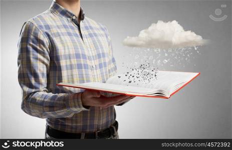 Guy with book in hands. Close view of man with opened book in hands and pages flying in air
