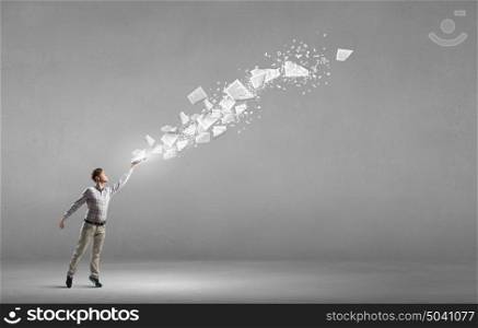 Guy with book in hands. Young businessman with opened book in hands and pages flying in air