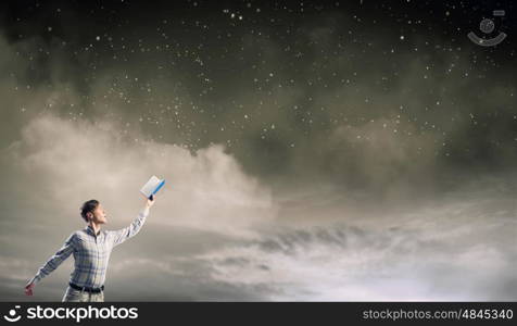 Guy with book in hands. Young man with book in hands and light coming from pages