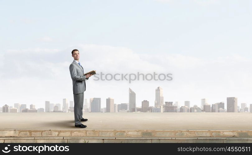 Guy with book. Young handsome businessman with old book in hands