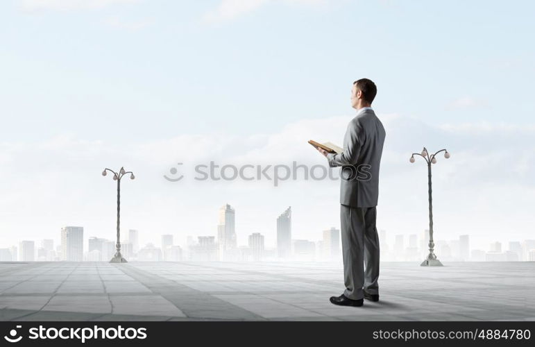 Guy with book. Young handsome businessman with old book in hands