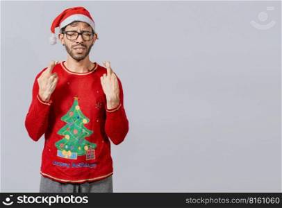 Guy with christmas hat making a wish on isolated background, Hopeful man in christmas clothes making a wish, Handsome man in christmas hat making a wish on white background