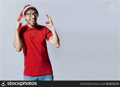 Guy with christmas hat making a wish on isolated background, Hopeful man in christmas clothes making a wish, Handsome man in christmas hat making a wish on isolated background
