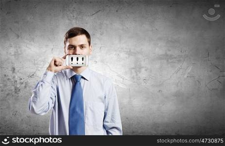 Guy with mobile phone. Young handsome businessman hiding mouth behind mobile phone