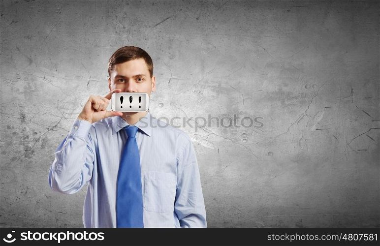 Guy with mobile phone. Young handsome businessman hiding mouth behind mobile phone