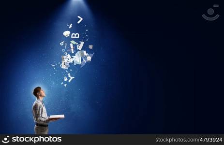 Guy with opened book in hands. Young man with book in hands and icons flying out from pages