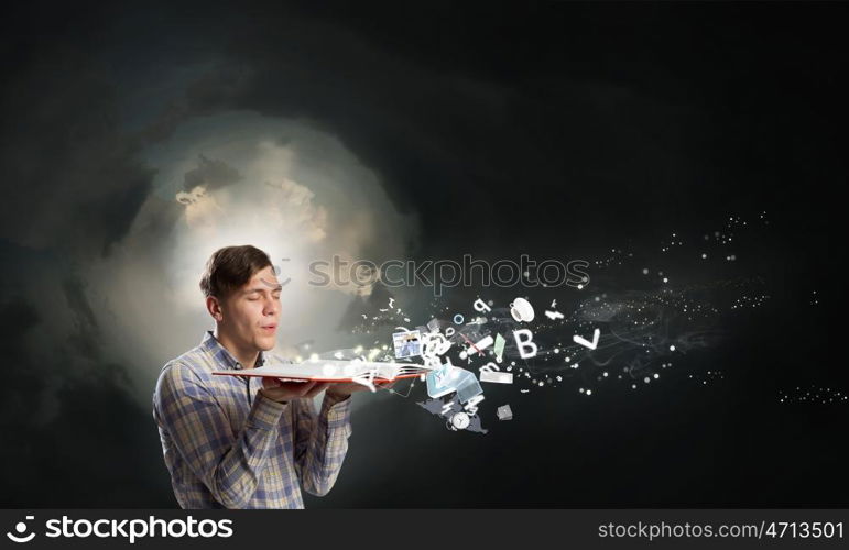 Guy with opened book. Young businessman with opened book in hands blowing on pages