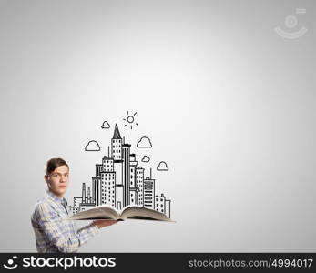 Guy with red book in hands. Young man in casual holding opened book with construction concept
