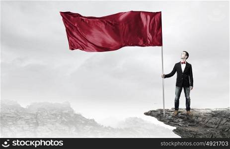 Guy with red flag. Young man in bowtie with waving flag on stick