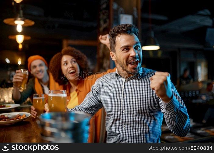 Guys drinking craft beer and watching football game. Diverse young people group rest in sports bar. Guys drinking craft beer and watching football game