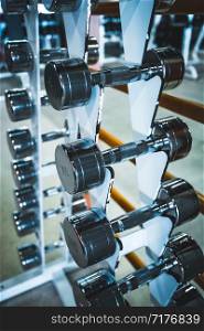 Gym and dumbbell weight training equipment on sport