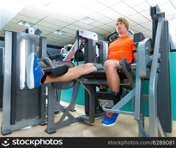 Gym blond man leg extension cuadriceps exercise workout at indoor