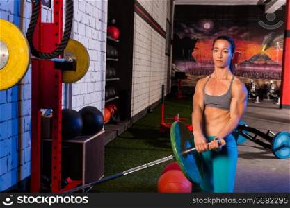 Gym girl lifting a barbell with fit strong body