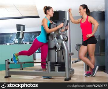 Gym glute exercise machine women workout smiling with personal trainer