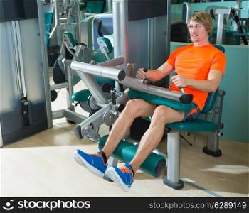 Gym seated leg curl machine exercise blond man at indoor