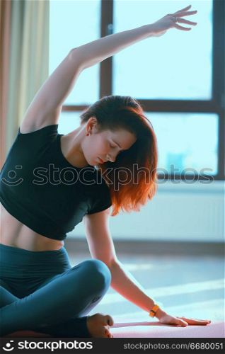 gymnasium, yoga classes / a girl engaged in yoga, a trom in a large gym, light and rays of the sun. concept of yoga for women