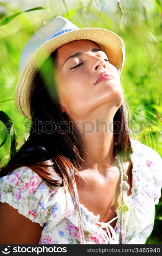 Gypsy girl with hat standing in field of wild flowers