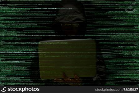Hacker using laptop stealing data on a code background. Computer security concept
