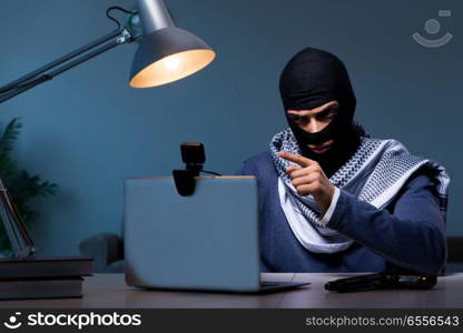 Hacker wearing balaclava mask hacking computer