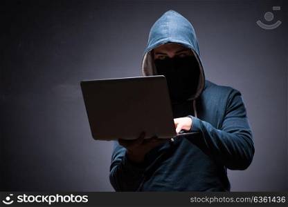 Hacker wearing hood in dark room