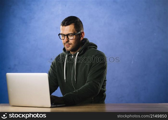 hacker with glasses looking laptop