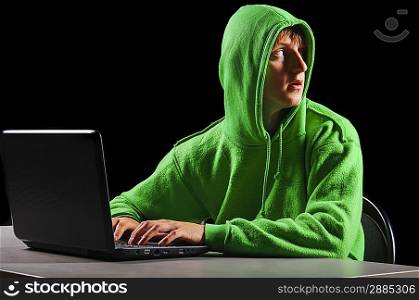 hacker. Young man with laptop is looking back