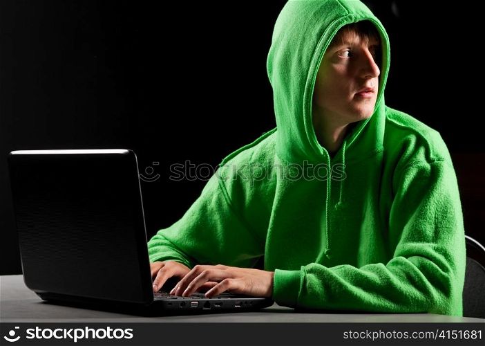 hacker. Young man with laptop is looking back