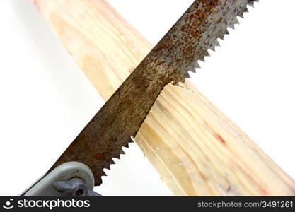 Hacksaw in sawed yellow wooden board on white background