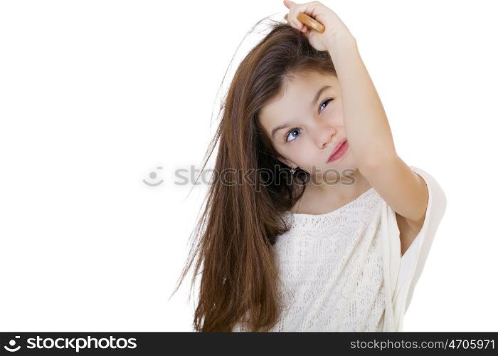 Hair care concept with portrait of little brunette girl brushing her unruly, tangled long hair isolated on white