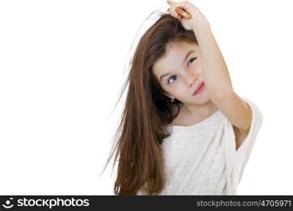 Hair care concept with portrait of little brunette girl brushing her unruly, tangled long hair isolated on white