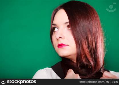 Hair care, hairdresser and hair stylist. Young red haired woman with long hair on neck on green background. Studio shot.