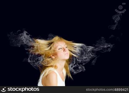 Hair care. Young attractive blond woman with hair in smoke