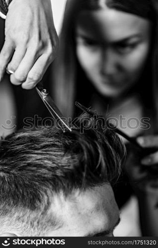 Hair styling man in hairsalon by female hairdresser