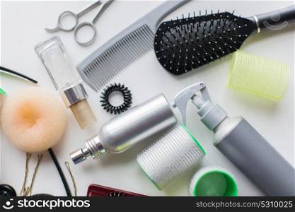 hair tools, beauty and hairdressing concept - brush, styling sprays, curlers and pins on white background. hair brush, styling sprays, curlers and pins