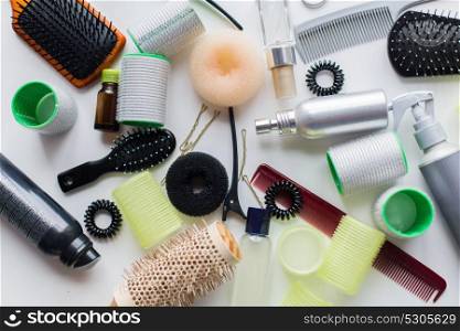 hair tools, beauty and hairdressing concept - brushes, styling sprays, curlers and pins on white background. hair brushes, styling sprays, curlers and pins
