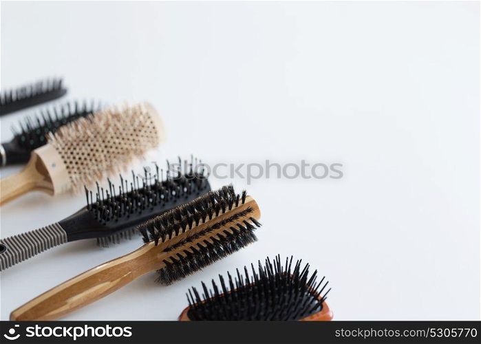 hair tools, beauty and hairdressing concept - different brushes or combs on white background. different hair brushes or combs
