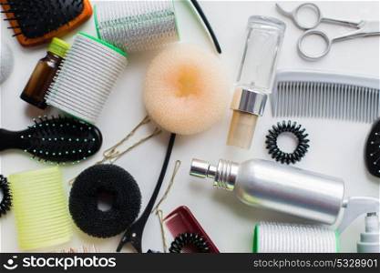 hair tools, beauty and hairdressing concept - donuts, styling sprays, curlers and pins on white background. hair donuts, styling sprays, curlers and pins