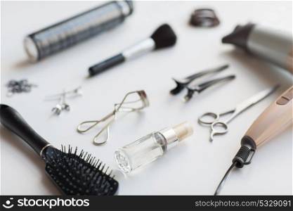 hair tools, beauty and hairdressing concept - hairdryer, scissors, comb and hot styling spay on white background. hairdryer, scissors and other hair styling tools