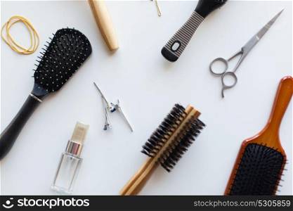 hair tools, beauty and hairdressing concept - scissors, different brushes, clips and styling spray on white background. scissors, hair brushes, clips and styling spray